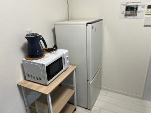 a microwave sitting on a table next to a refrigerator at 花園之家 in Osaka
