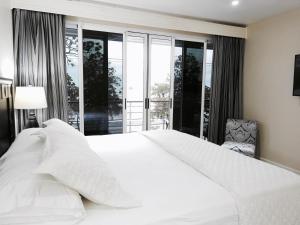 Un dormitorio con una gran cama blanca y una ventana en The Elephant Castle Beach Front Penthouse, en Manuel Antonio