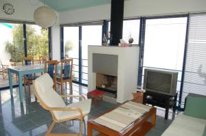 a living room with a fireplace and a tv at Cottage in Tiros