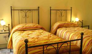 two beds sitting next to each other in a bedroom at I Colori Del Sole in Fiumefreddo di Sicilia