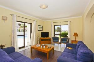 un salon avec des canapés violets et une table dans l'établissement Villa Eira by Villa Plus, à Praia do Carvoeiro