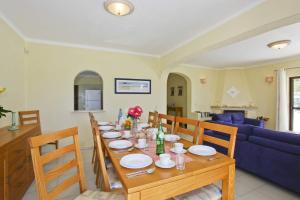 une salle à manger avec une table et un canapé bleu dans l'établissement Villa Eira by Villa Plus, à Praia do Carvoeiro