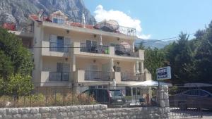 a large white building with a sign in front of it at Apartments Pejanović in Kotor