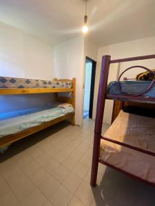 Cette chambre comprend 2 lits superposés et une chaise. dans l'établissement Apartamento El Gauchito en Cosquin, à Cosquín