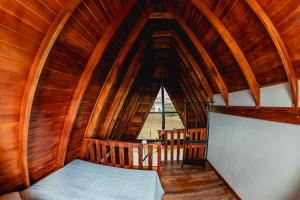 een kamer met een bed in een houten hut bij Chalé Tia Barbara in Itutinga