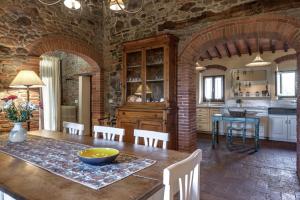 une cuisine et une salle à manger avec une table et des chaises en bois dans l'établissement Podere Vecciale, à Cavriglia 20 autres photos