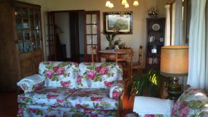 a living room with a floral couch and a table at Casa Do Moinho in Colares +31 photos