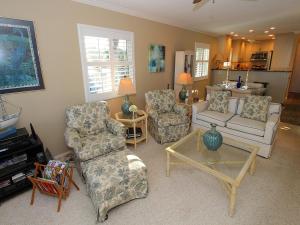 un soggiorno con un divano, sedie e un tavolo di Whitney Beach #142 a Whitney Beach