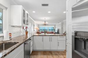 een keuken met witte kasten, een gootsteen en een raam bij Whitney Beach #316 in Whitney Beach