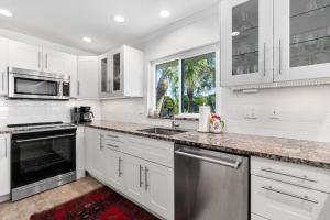 een keuken met witte kasten en roestvrijstalen apparaten bij Whitney Beach #316 in Whitney Beach