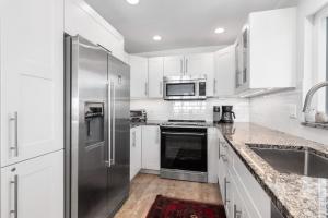 een keuken met witte kasten en een roestvrijstalen koelkast bij Whitney Beach #316 in Whitney Beach