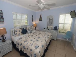 a bedroom with a bed and a ceiling fan at Silver Sands #232 in Longboat Key