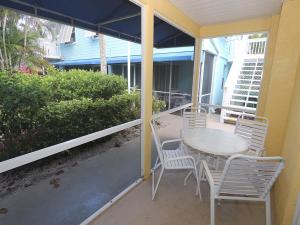 a patio with a table and chairs on a porch at Silver Sands #232 in Longboat Key