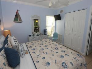 a bedroom with a bed with a comforter on it at Silver Sands #232 in Longboat Key