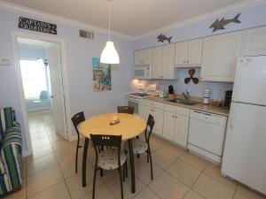 a kitchen with a table and chairs and a refrigerator at Silver Sands #232 in Longboat Key