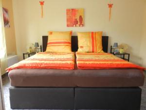 - un lit avec des oreillers orange et jaune dans l'établissement Ferienwohnung Preiser In Schieder Schwalenberg, à Schieder-Schwalenberg