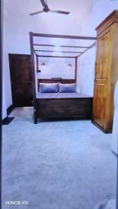 1 dormitorio con cama de madera y vestidor en Doctor house ahangama, en Ahangama