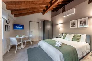 ein Schlafzimmer mit einem Bett und einem Tisch mit Stühlen in der Unterkunft Alta Via 4 - Free Parking - Sea 20 min - A-C in Altare