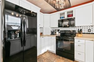 a kitchen with black appliances and white cabinets at Beach Breeze East in Bradenton Beach