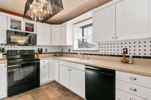a kitchen with white cabinets and a black dishwasher at Beach Breeze East in Bradenton Beach
