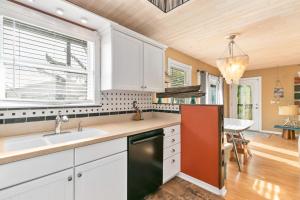 a kitchen with white cabinets and a sink and a window at Beach Breeze East in Bradenton Beach