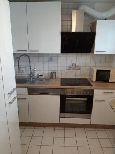 a kitchen with a sink and a stove top oven at Chic 2-room apartment very central and quiet in Eislingen