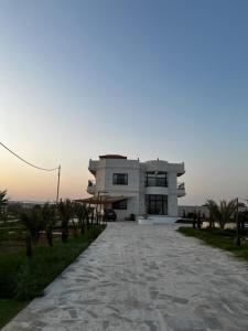 ein großes weißes Haus mit einer Einfahrt davor in der Unterkunft Rest Sea Chaliet & Farm 