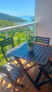 einem blauen Picknicktisch mit Topfpflanze auf dem Balkon in der Unterkunft sunshine home in Paraty