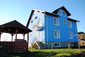 a blue building with a gazebo in front of it at Casa Sidor in Baile Felix