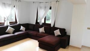 a living room with a brown couch and windows at Ferienhaus In Pedruscada Mit Privatem Pool in Cala Ratjada