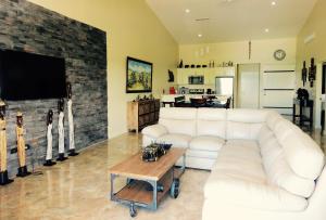 a living room with a white couch and a tv at The Elephant Castle Beach Front Penthouse in Manuel Antonio