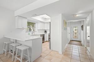 una cucina con armadi bianchi, bancone e sgabelli di Whitney Beach #315 a Whitney Beach Altre 24 foto
