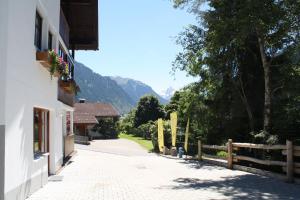 a street with a fence and mountains in the background at Ruhige Wohnung Im Ortszentrum in Sankt Gallenkirch +17 photos