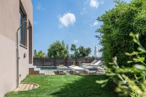 a backyard with lounge chairs and a swimming pool at Happy Villa in Galatás