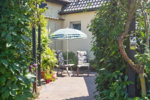 un patio avec une table, un parasol et des chaises dans l'établissement Appartement In Süd, à Dessau