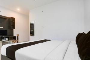 sypialnia z białym łóżkiem i telewizorem z płaskim ekranem w obiekcie Hotel O The Hunger Byte Resort w mieście Bodh Gaja +21 zdjęć