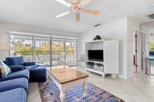 un soggiorno con un divano blu e una TV di Whitney Beach #132 a Whitney Beach