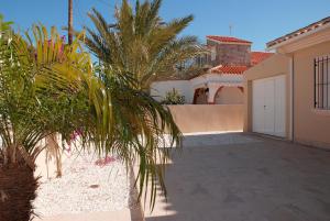 ein Haus mit Palmen vor einer Einfahrt in der Unterkunft Ferienhaus mit Privatpool für 8 Personen ca 146 m in Estrella de Mar, Murcia Costa Calida in Los Urrutias