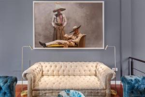 a painting of a man sitting in a chair next to a woman at Ziggy Blues in Arrecife