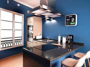 a kitchen with a black counter and a blue wall at Ziggy Blues in Arrecife