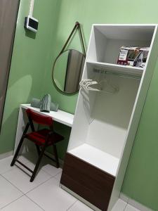 a white cabinet with a mirror and a red chair at ORLA FLAT - Apartamento 02 in Bragança