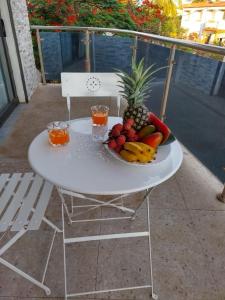 una mesa blanca con fruta y bebidas en el balcón en Résidence DELIA, en Antsiranana