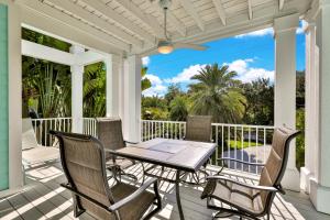 een patio met een tafel en stoelen op een veranda bij Aqua Bay in Longbeach
