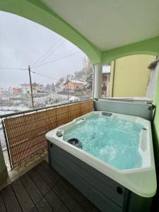 una bañera de hidromasaje en un balcón con una cubierta de nieve en Villa Zoe - Sauna & Hot Spa, en Margone