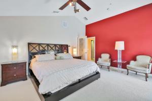 een slaapkamer met een groot bed en een rode muur bij Aqua Bay in Longbeach +15 foto's