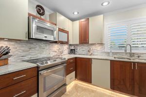 una cucina con armadietti in legno ed elettrodomestici in acciaio inossidabile di Whitney Beach #186 a Whitney Beach