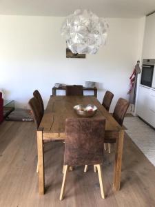 a wooden dining room table with chairs and a chandelier at Motta Rotonda in Maloja