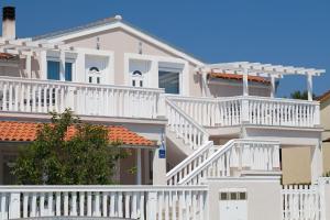 ein weißes Haus mit weißen Geländern und Treppen in der Unterkunft Moderne Ferienwohnung mit jacuzzi in Ližnjan