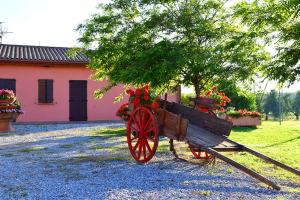 een houten kar met bloemen erop naast een gebouw bij Suite Orchidea Seaside and Pool in La Caduta