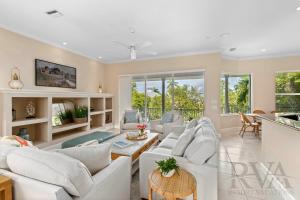 un soggiorno con divani bianchi e tavolo di Marbury Lane a Sister Keys